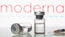 vaccine vials in front of moderna logo vaccine vials in front of moderna logo