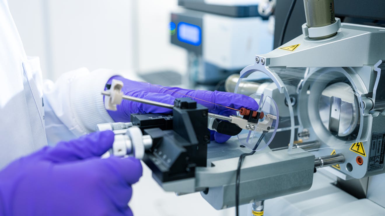 Close up of gloved researcher's hands working on equipment in a Lonza biologics development lab