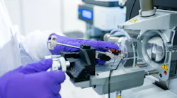 Close up of gloved researcher's hands working on equipment in a Lonza biologics development lab