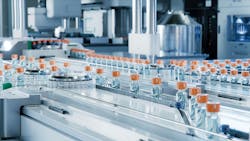Modern Pharmaceutical Factory. Medical Ampoule Production Line. Rows of Glass Vials with Orange Caps on Conveyor Belt. Modern Pharmaceutical Factory. Medical Ampoule Production Line. Rows of Glass Vials with Orange Caps on Conveyor Belt.