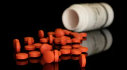 Lot of whole orange tablet pharmacy with plastic bottle isolated on black glass