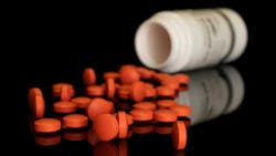 Lot of whole orange tablet pharmacy with plastic bottle isolated on black glass Lot of whole orange tablet pharmacy with plastic bottle isolated on black glass