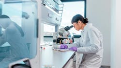 Female Akadeum scientist in lab looking into microscope Female Akadeum scientist in lab looking into microscope