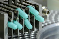 Close-up shot of medicine capsules in tablet manufacturing machine Close-up shot of medicine capsules in tablet manufacturing machine