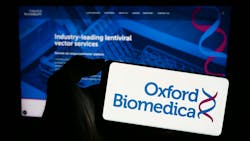Person holding mobile phone with logo of British gene therapy company Oxford Biomedica plc in front of business web page Person holding mobile phone with logo of British gene therapy company Oxford Biomedica plc in front of business web page