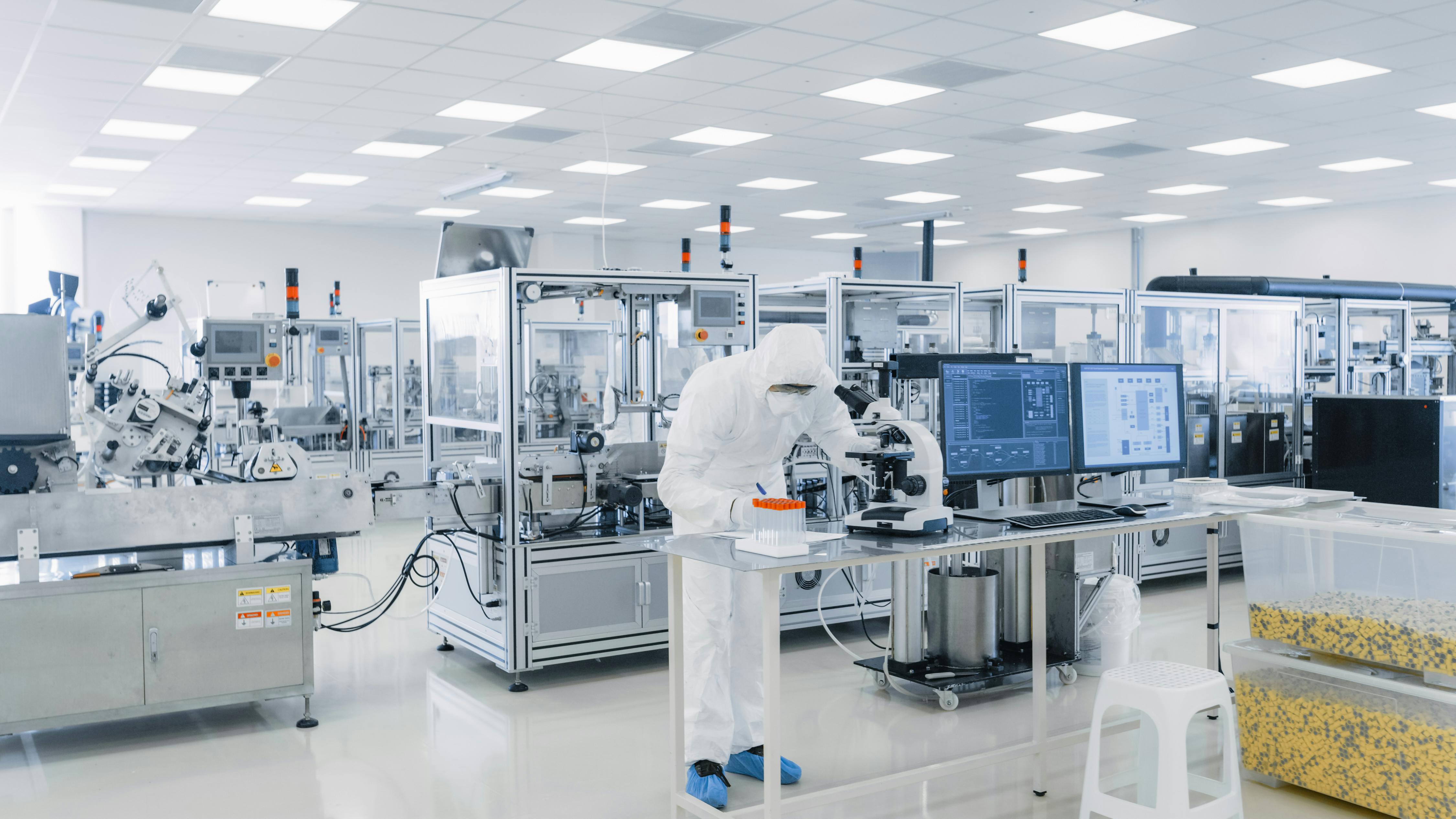 Shot of Sterile Pharmaceutical Manufacturing Laboratory where Scientists in Protective Coverall's Do Research, Quality Control and Work on the Discovery of new Medicine
