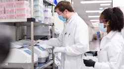 Workers in labcoats in Moderna facility