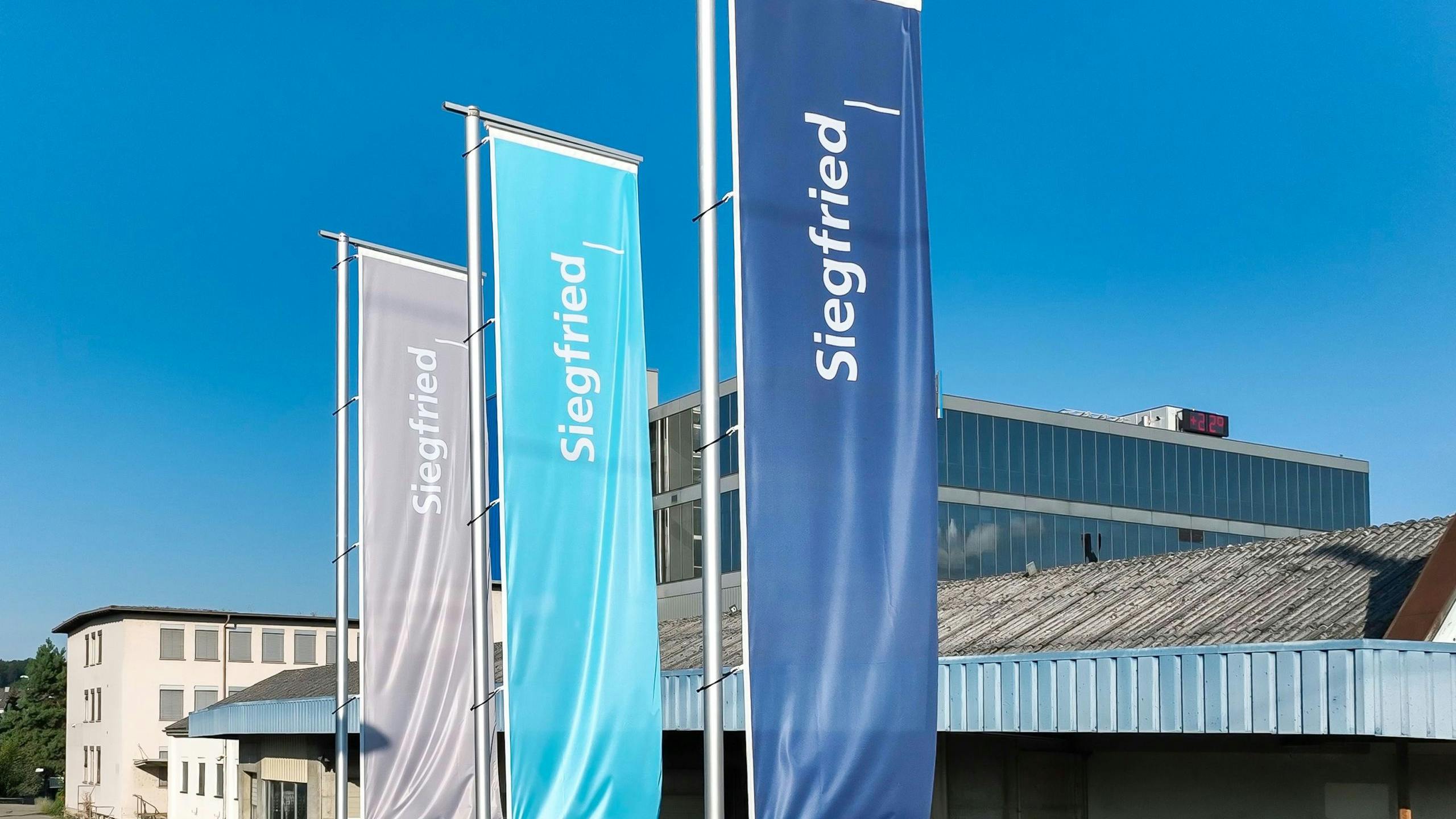 Banner flags with Siegfried logo at company headquarters