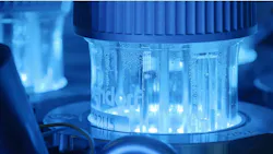 Close-up of an Eppendorf laboratory bioreactor vessel glowing blue with bubbling liquid inside. Close-up of an Eppendorf laboratory bioreactor vessel glowing blue with bubbling liquid inside.