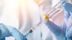 Gloved hands draw liquid from a glass medication vial into a syringe in a clinical setting. Gloved hands draw liquid from a glass medication vial into a syringe in a clinical setting.