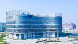 Aerial view of WuXI Biologic DP15 in Fengxian, China - a modern curved glass biopharmaceutical facility building- on a clear day. Aerial view of WuXI Biologic DP15 in Fengxian, China - a modern curved glass biopharmaceutical facility building- on a clear day.