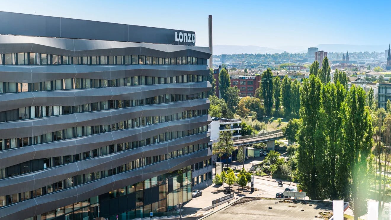 Exterior building with Lonza logo on facade with panoramic view of surrounding area in background