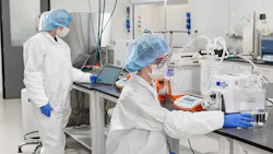 Pharmaceutical workers in PPE in lab at new TriLink facility Pharmaceutical workers in PPE in lab at new TriLink facility