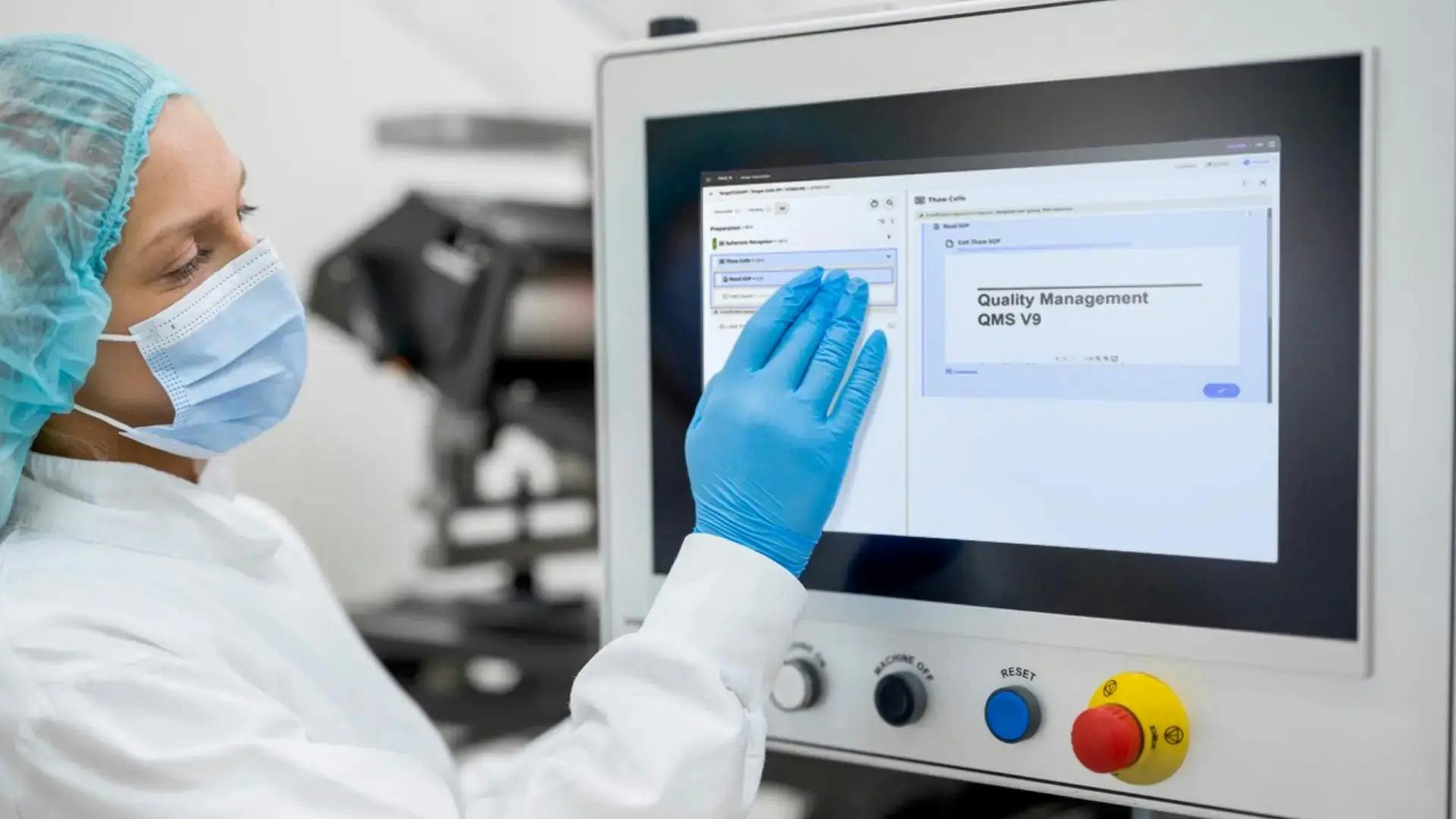 Pharmceutical work in blue mask and gloves stands in front of control panel for manufacturing execution system