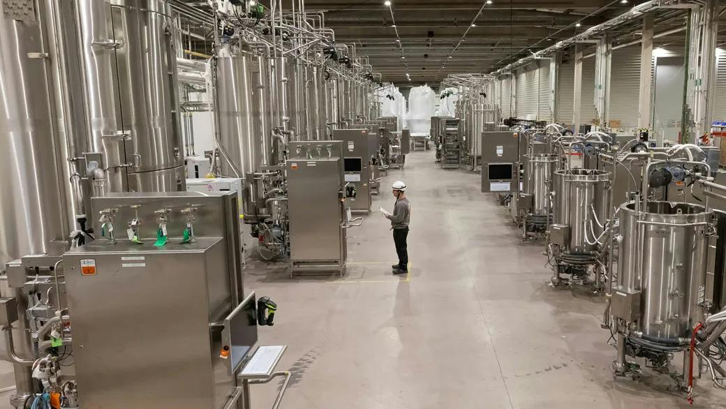 Worker stands inside large ABEC manufacturing facility