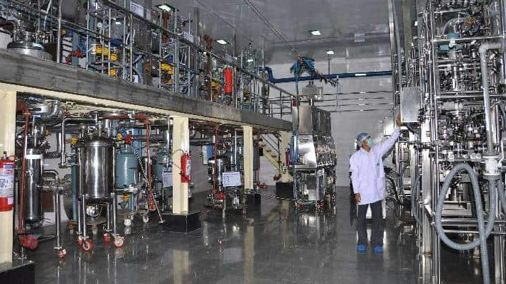 Worker inspects equipment inside pharma facility